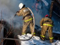 Два сотрудника МЧС России тушат пожар